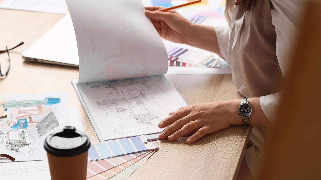 Interior designer selecting fabric swatches and color palettes for a transitional living room decor project.